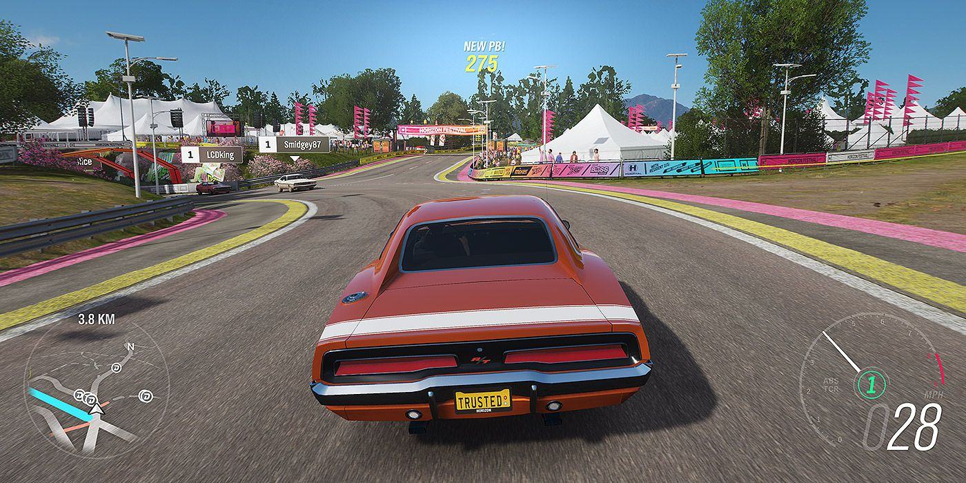 Một chiếc xe cơ bắp cổ điển đua quanh đường đua lễ hội của Forza Horizon 4.