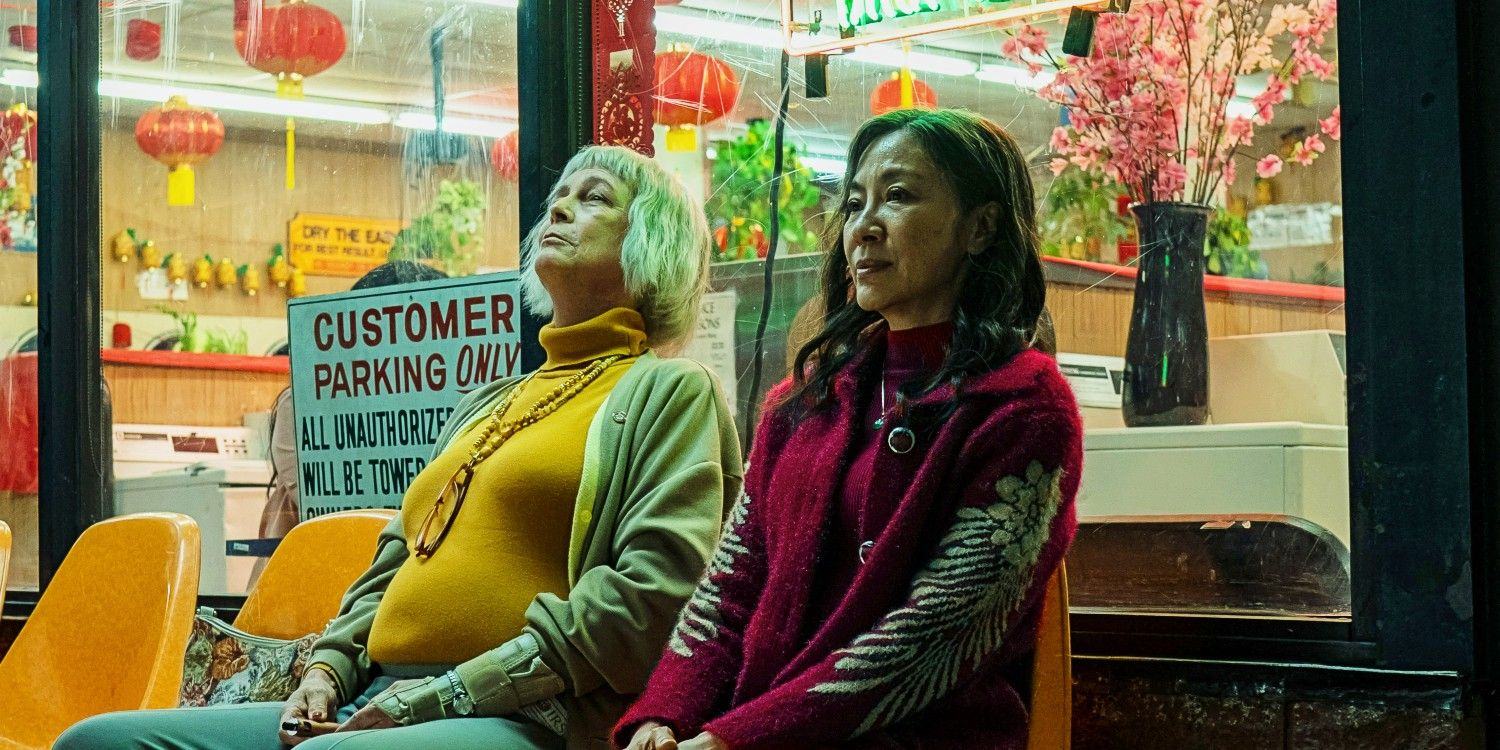 Jamie Lee Curtis and Michelle Yeoh sitting outside the laundromat