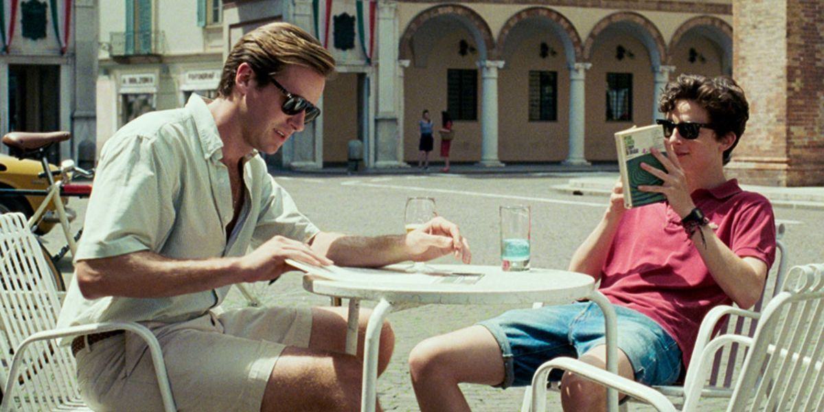 In Call Me By Your Name, Oliver and Elio sit at an outdoor table