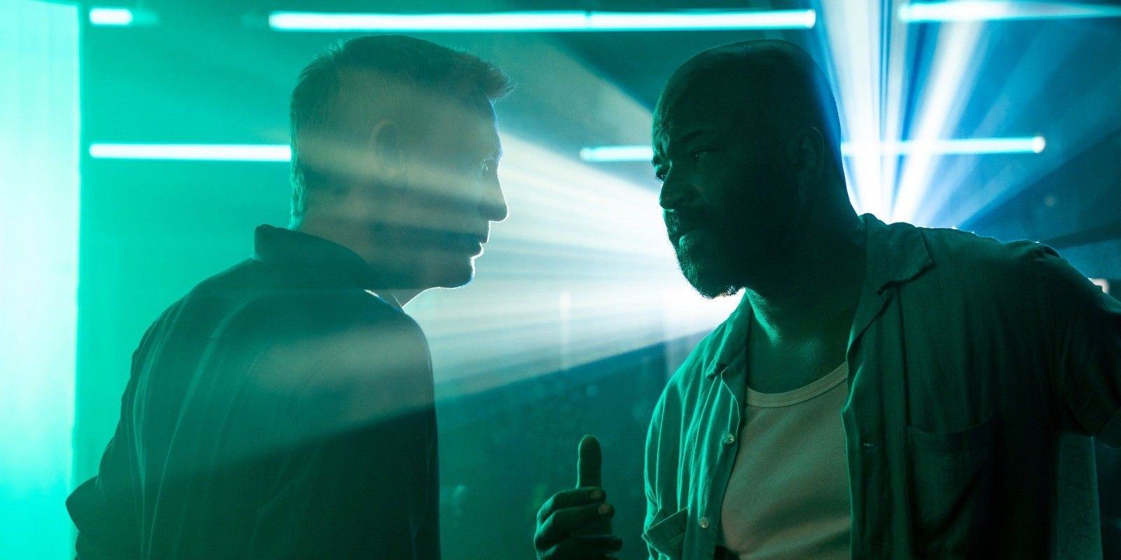 Bond and Felix chat in front of bright lights.