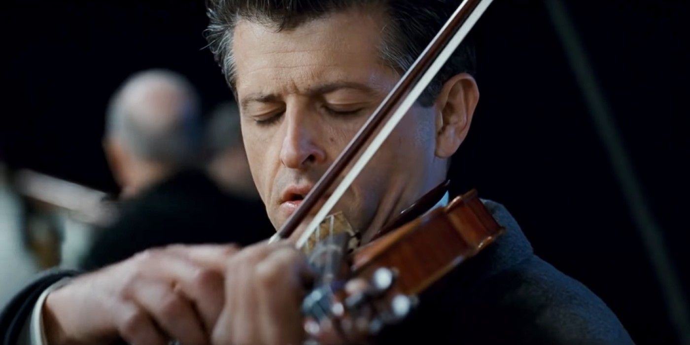 A musician plays the violin as the Titanic sinks.