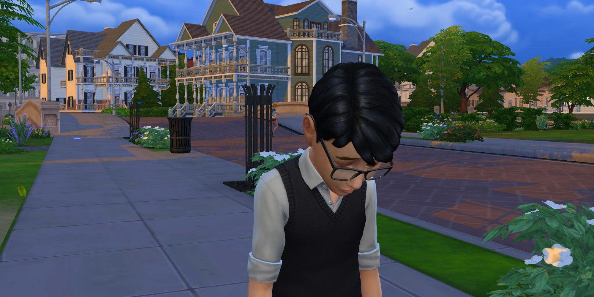 A young Sim from The Sims 4 looks very sad standing on the sidewalk with two mansions in the background.