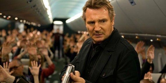 Liam Neeson with a gun in the aisle of the plane in Non-Stop