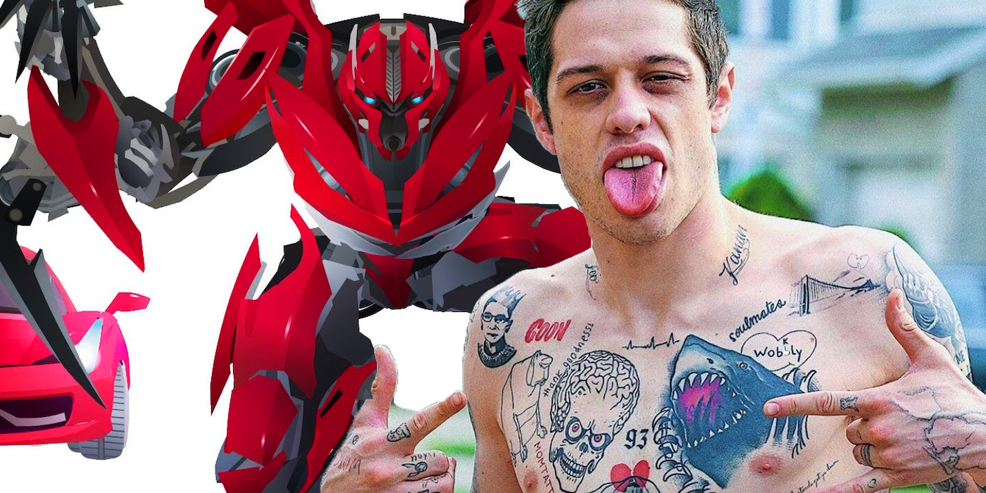 A tattooed man standing grimacing in front of a red robot