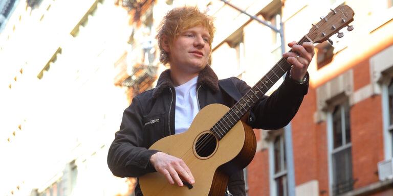 Ed Sheeran gets in a car with his guitar to perform for his fans in New York after a huge court win