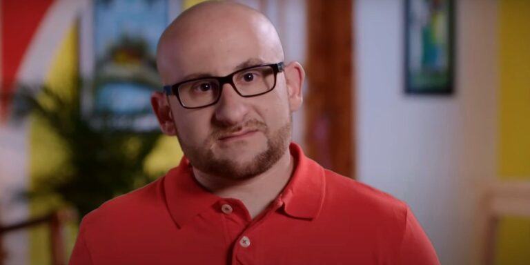 Mike Berk wearing a red shirt in 90 Day Fiancé  serious expression