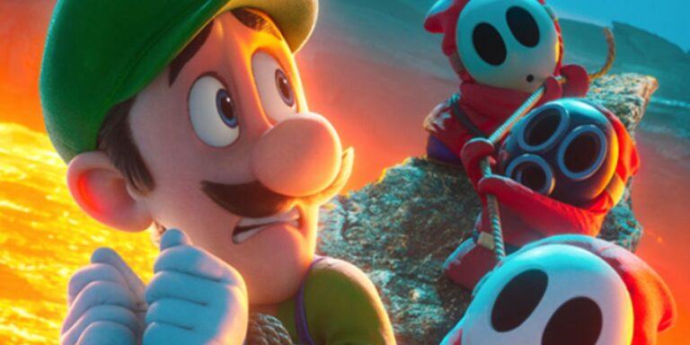 Luigi looks fearfully at some shy guys in a poster for The Super Mario Bros. Movie.